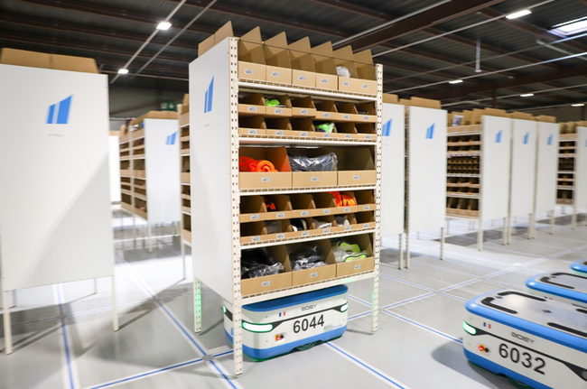 La solution  de stockage automatisé « Goods to Man » de SCALLOG repose sur un système de robots autonomes et d’étagères mobiles.<br>
                              Crédit photo : SCALLOG